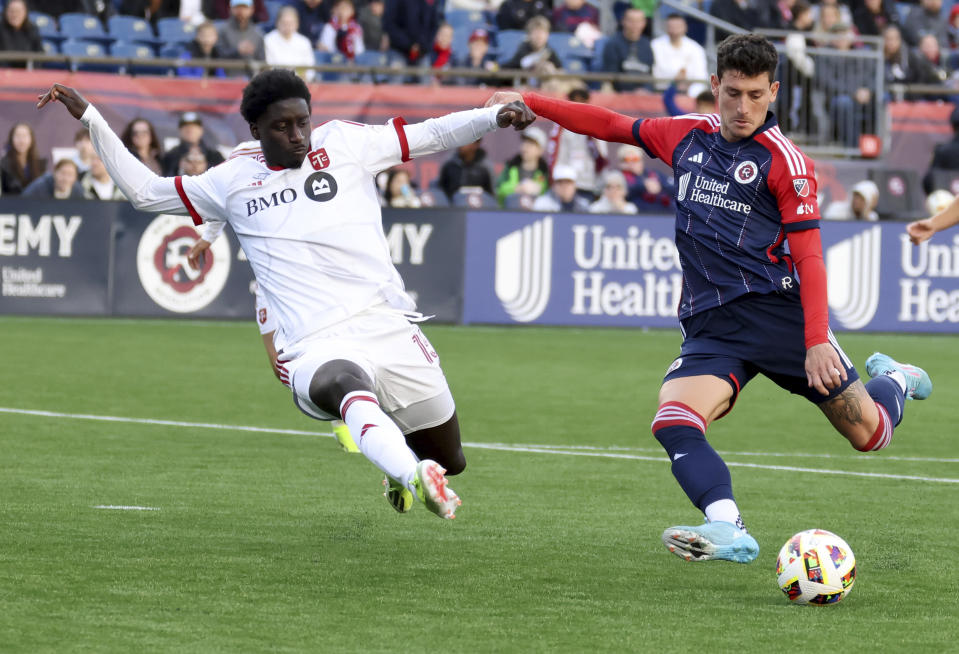 Toronto FC defender Nicksoen Gomis, left, and New England Revolution forward Tomas Chancalay, right, fight for the ball in the second half of an MLS soccer match, Sunday, March 3, 2024, in Foxborough, Mass. (AP Photo/Mark Stockwell)