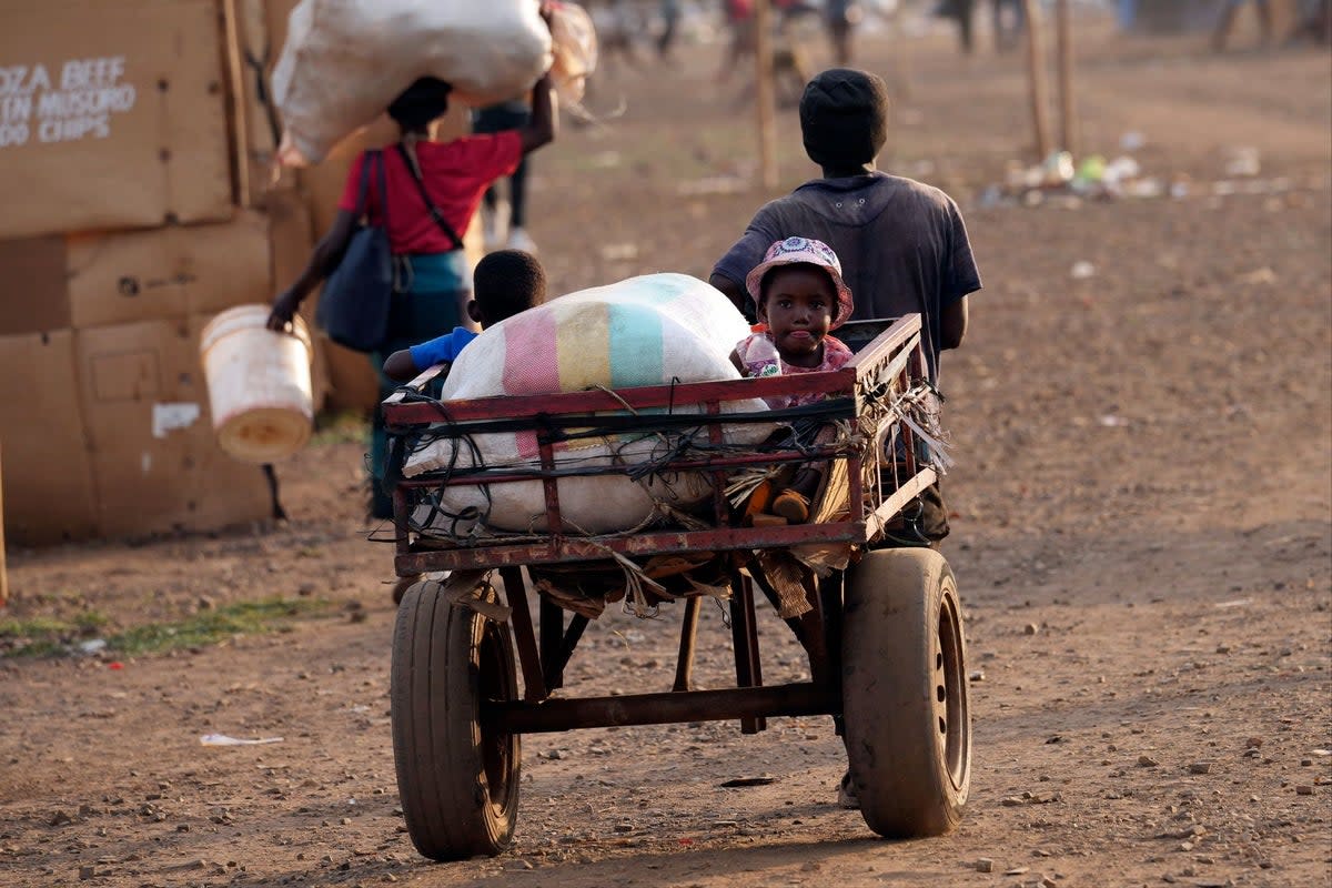 Children are transported using a push cart in Mbare, a neighbourhood in Harare (AP)