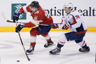 Florida Panthers center Maxim Mamin (98) and Washington Capitals defenseman John Carlson (74) battle for the puck during the first period of an NHL hockey game, Tuesday, Nov. 30, 2021, in Sunrise, Fla. (AP Photo/Wilfredo Lee)