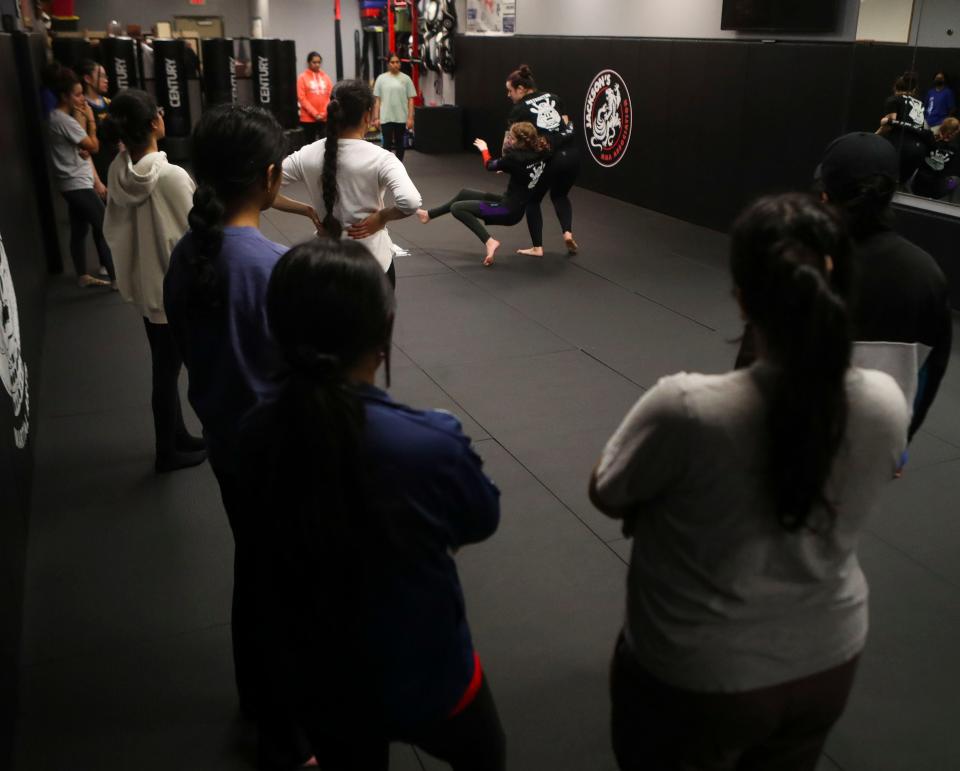 Instructors Aliyah Friend (left) and Rebecca Evans demonstrate self defense techniques for Girls Unite for Defense members at Delaware Dragon Martial Arts.