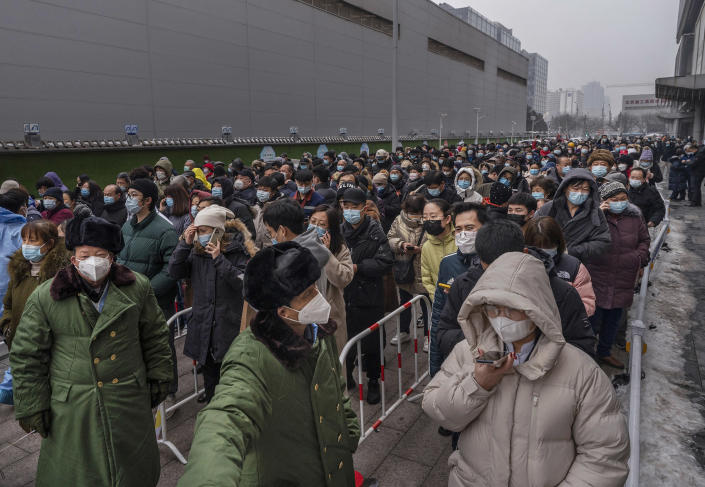 Security stand in front of people as they line up for nucleic acid tests to detect COVID-19 at a mass testing site on January 24, 2022 in Beijing, China. While China has mostly contained the spread of COVID-19 during the pandemic, and even though cases remain relatively low, recent outbreaks of the virus including the emergence of the highly contagious Omicron variant have prompted the government to lockdown people in various major cities and to reinforce stricter health measures. Mask mandates, mass testing, immunization boosters, quarantines, some travel restrictions and bans and lockdowns have become the norm as China continues to maintain its zero-COVID policy.<span class="copyright">Kevin Frayer—Getty Images</span>