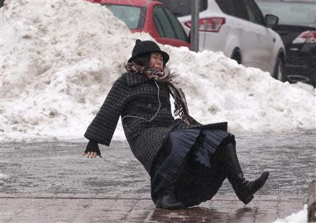 A woman falls while slipping on ice during freezing rain on Roosevelt Island in Manhattan, New York City January 5, 2014. REUTERS/Zoran Milich