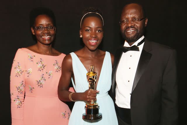 <p>Christopher Polk/Getty</p> Lupita Nyong'o (center) with parents Dorothy and Peter on March 2, 2014