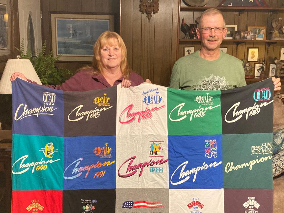 Brenda and Rick Rodland of Harborcreek Township pose with a blanket comprised of Highmark Quad Games T-shirts. Rick Rodland was given the shirts over nearly 40 years of competing in the Quad. He and McKean Township resident Ronnie Graff are the only people who have participated in every Quad event since the competition began in 1983.
