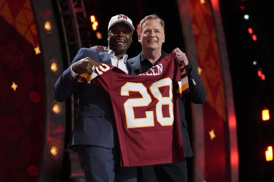 NFL Commissioner Roger Goodell, right, poses with former player Darrell Green reacts while on stage to announce the Washington Commanders pick during the second round of the NFL football draft, Friday, April 26, 2024, in Detroit. (AP Photo/Jeff Roberson)