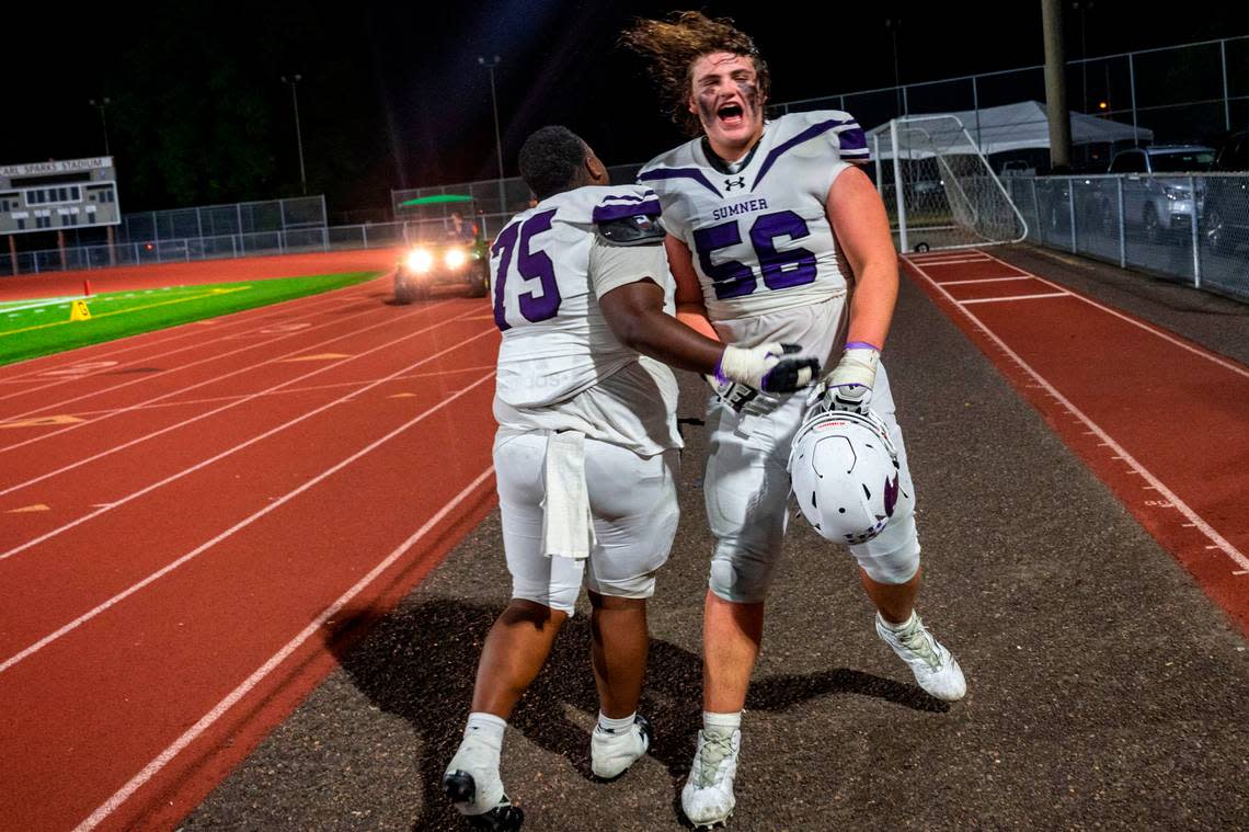 Sumner’s Rayvoughn “Bubba” Varnado (75) and Dylan Sikorsky celebrate as the leave the field after beating Puyallup, 40-10, in a A SPSL game on Friday, Sept. 23, 2022, at Sparks Stadium in Puyallup, Wash.