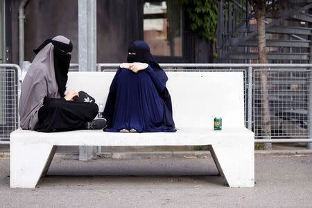 Sabina (L), 21, and Alaa, both students and wearers of the niqab, sit in a park in Copenhagen, Denmark, July 17, 2018. REUTERS/Andrew Kelly