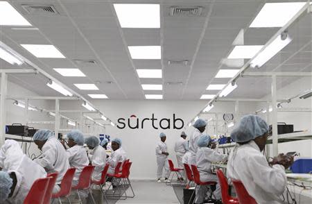 Workers assemble Android-based tablets from imported components at the Surtab factory in the Sonapi Industrial Park of Port-au-Prince March 11, 2014. REUTERS/Marie Arago