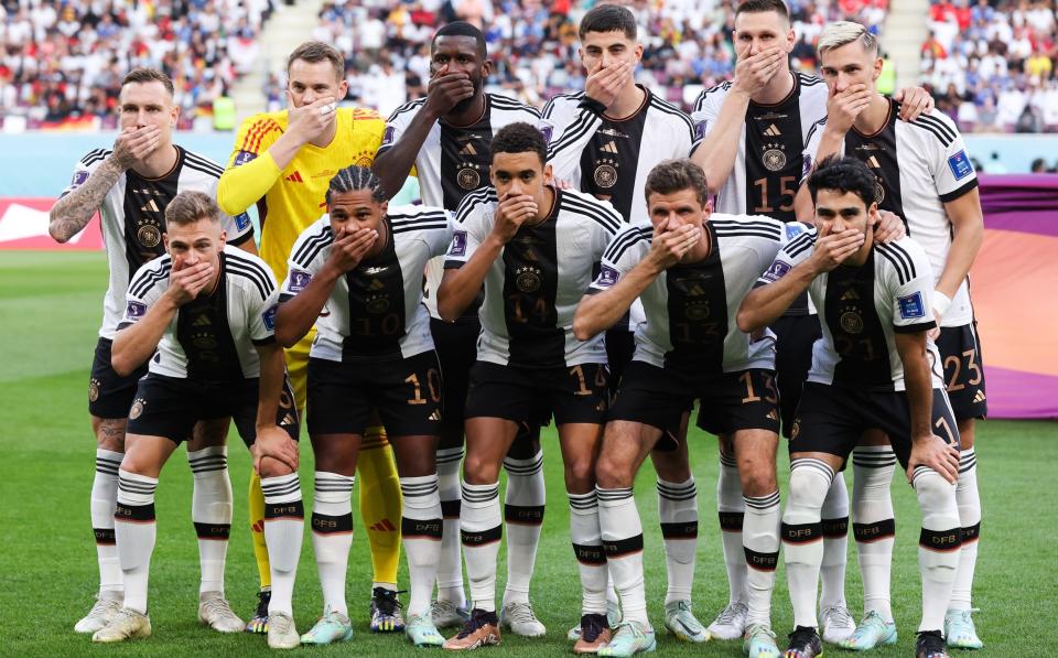 Germany players in group protest/Germany players cover their mouths as they pose for a team photo - GETTY IMAGES/ALEX LIVESEY