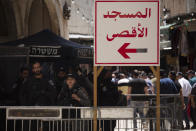 Israeli police stand at a checkpoint with a sign in Arabic that reads, "Al-Aqsa Mosque," in the Old City of Jerusalem for Friday prayers during the Muslim holy month of Ramadan, on Friday, April 23, 2021. Israeli police say 44 people were arrested and 20 officers were wounded in a night of chaos in Jerusalem, where security forces separately clashed with Palestinians angry about Ramadan restrictions and Jewish extremists who held an anti-Arab march nearby. (AP Photo/Maya Alleruzzo)