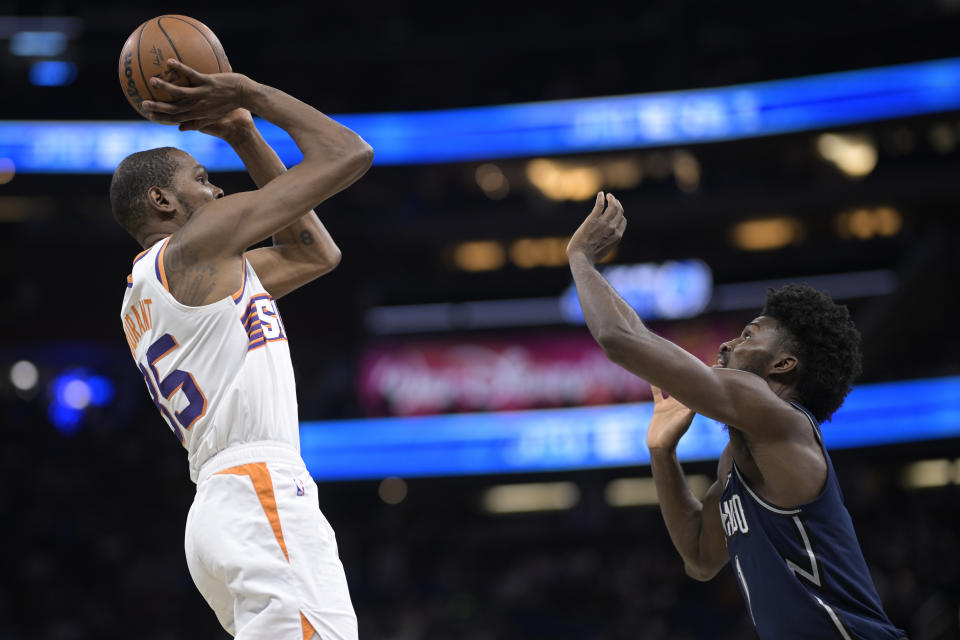 Phoenix Suns forward Kevin Durant, left, looks to shoot in front of Orlando Magic forward Jonathan Isaac, right, during the second half of an NBA basketball game, Sunday, Jan. 28, 2024, in Orlando, Fla. (AP Photo/Phelan M. Ebenhack)