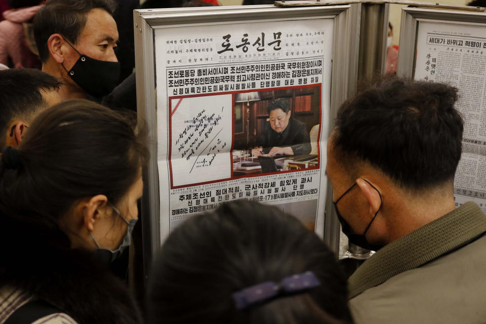 FILE - People look at a copy of North Korea' newspaper Rodong Sinmun showing the report about the test-launch of a missile, at the Jonsung Station of Pyongyang Metro in Pyongyang, North Korea, on March 25, 2022. North Korean leader Kim Jong Un vowed to develop additional “powerful strike means” and perfect the country’s nuclear deterrent, state media reported Monday, March 28, days after the North performed its first intercontinental ballistic missile launch in years.(AP Photo/Cha Song Ho, File)