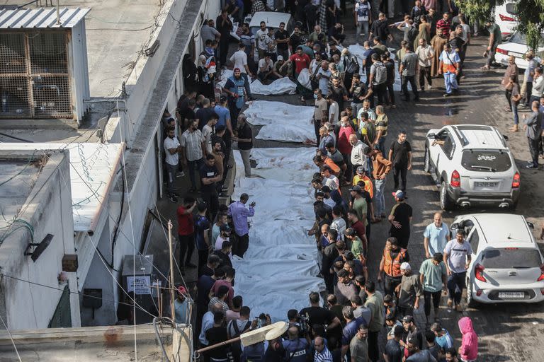 Palestinos se congregan alrededor de los cuerpos de las víctimas asesinadas durante los ataques aéreos israelíes, fuera de la morgue del hospital Al-Shifa en la Ciudad de Gaza.