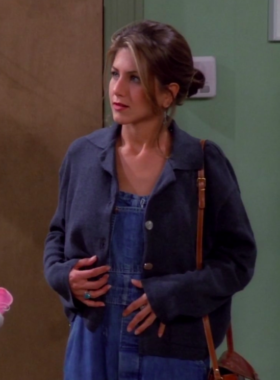 Rachel wearing a shoulder bag, a cardigan, and overalls