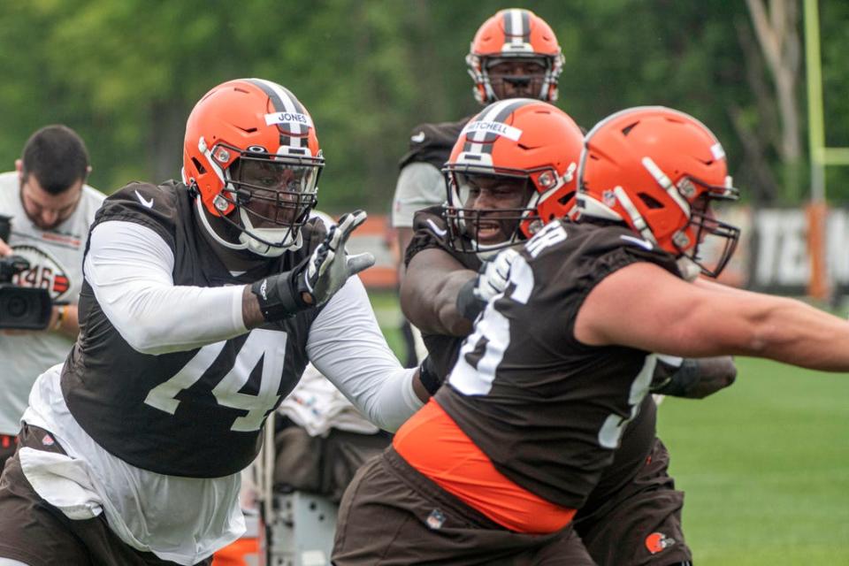 Browns offensive linemen Dawand Jones (74) and Luke Wypler, right, run a drill May 12 during rookie minicamp in Berea.