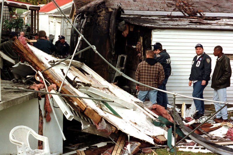 Police investigate a section of the American Airlines Flight 587 airplane that crashed into a house, setting it on fire before the plane hit ground a few blocks away in the Rockaway section of Queens in New York City on November 12, 2001. File Photo by Monika Graff/UPI