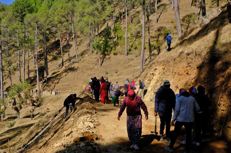 Workers build a path in the hill as part of an alternate plan to reach to the workers trapped in a tunnel after a portion of the tunnel collapsed in Uttarkashi