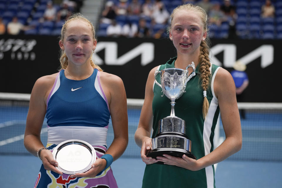 Alina Korneeva, right, of Russia holds her trophy after defeating compatriot Mirra Andreeva in the girls' singles final at the Australian Open tennis championship in Melbourne, Australia, Saturday, Jan. 28, 2023. (AP Photo/Aaron Favila)