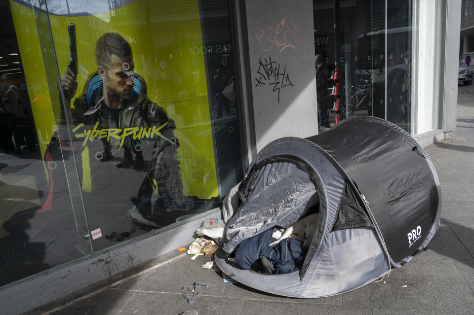 Homeless person and their dog sleeping in a tent outside a shop on Tottenham Court Road with an advert for Cyberpunk in the window on March 11th 2023 in London, United Kingdom. (photo by Jenny Matthews/In Pictures via Getty Images)