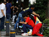 People sit in queue for the release of Apple's new iPhone 7 and 7 Plus in front of the Apple Store in Tokyo's Omotesando shopping district, Japan September 15, 2016. REUTERS/Toru Hanai