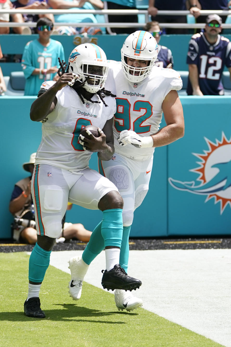 Miami Dolphins defensive tackle Zach Sieler (92) celebrates linebacker Melvin Ingram (6) after Ingram recovered a fumble and ran for a touchdown during the first half of an NFL football game against the New England Patriots, Sunday, Sept. 11, 2022, in Miami Gardens, Fla. (AP Photo/Lynne Sladky)