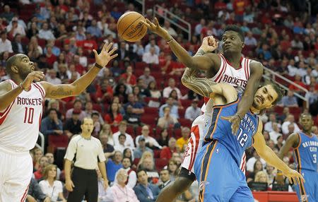 Nov 2, 2015; Houston, TX, USA; Houston Rockets center Clint Capela (15) fouls Oklahoma City Thunder center Steven Adams (12) while Houston Rockets guard Marcus Thornton (10) reaches for the ball in the fourth quarter at Toyota Center. Rocket won 110 to 105. Mandatory Credit: Thomas B. Shea-USA TODAY Sports