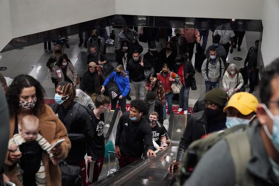 Travelers ride the escalator after their flight arrives at the Hartsfield-Jackson Atlanta International Airport on Tuesday, Nov. 23, 2021, in Atlanta.