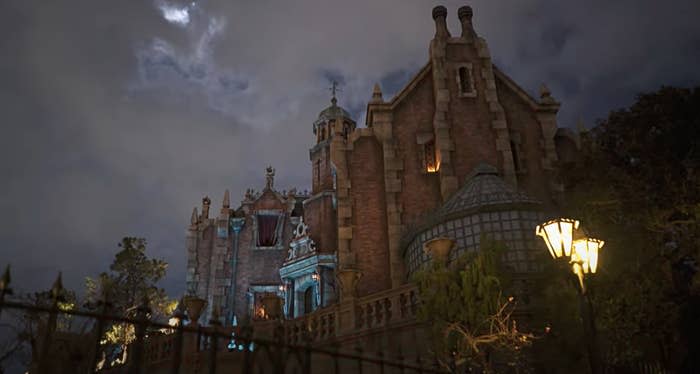 Exterior of the Haunted Mansion in Tokyo Disneyland, which features a brick building and a small greenhouse