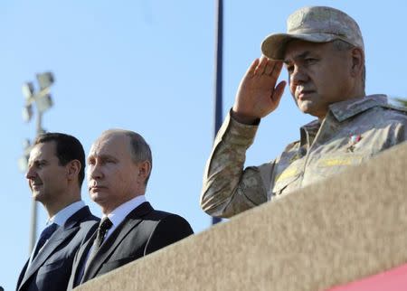 Russian President Vladimir Putin (C), Defence Minister Sergei Shoigu (R) and Syrian President Bashar al-Assad visit the Hmeymim air base in Latakia Province, Syria December 11, 2017. Sputnik/Mikhail Klimentyev/Sputnik via REUTERS