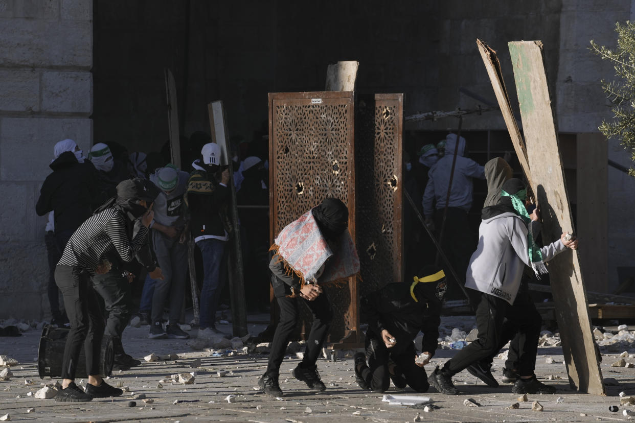 Palestinians clash with Israeli security forces at the Al Aqsa Mosque compound in Jerusalem's Old City Friday, April 15, 2022. (AP Photo/Mahmoud Illean)