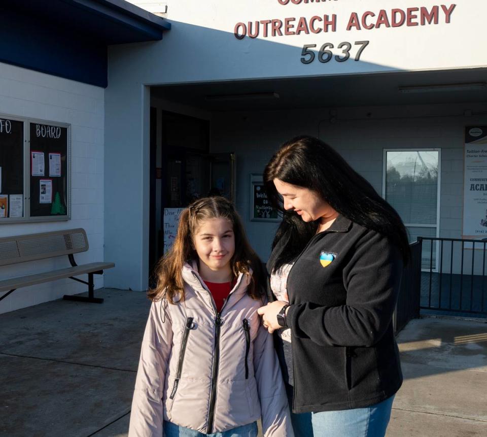 Ukrainian refugees Tetiana Tyshchenko and daughter Valeriia Tyshchenko, 10, stand outside of the Community Outreach Academy school at McClellan Park on Dec. 15. The academy wants to bring warm winter clothes and night of snow to campus to give their 164 refugee students from Ukraine and Afghanistan a taste of home.