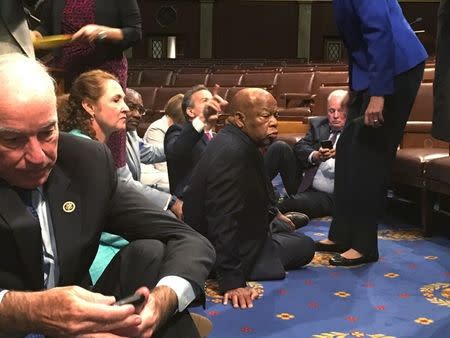 A photo shot and tweeted from the floor of the House by U.S. House Rep. John Yarmuth shows Democratic members of the U.S. House of Representatives, including Rep. Joe Courtney (L) and Rep. John Lewis (C) staging a sit-in on the House floor "to demand action on common sense gun legislation" on Capitol Hill in Washington, United States, June 22, 2016. REUTERS/U.S. Rep. John Yarmuth/Handout