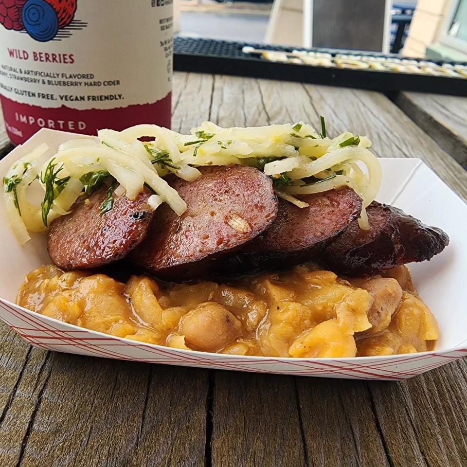 Smoked lamb sausage on yellow peas braised with pork belly and kohlrabi slaw at Oskar's Slider Bar in Louisville.