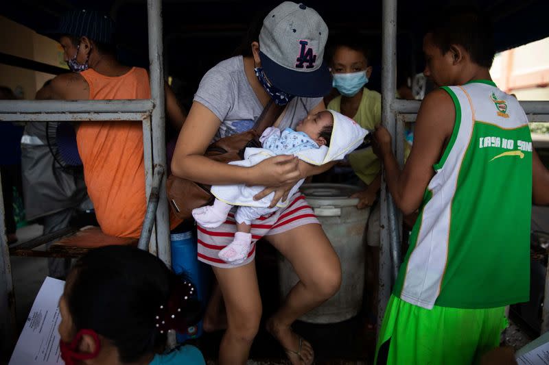 Residents in a coastal community in Metro Manila evacuate ahead of Typhoon Vamco