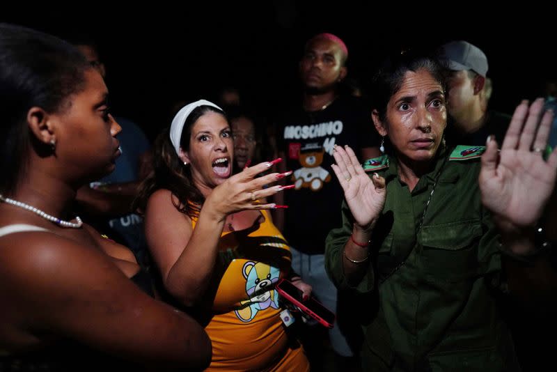 Una funcionaria del partido comunista local habla a los manifestantes frente a una oficina del partido comunista en una protesta contra un apagón tras el paso del huracán Ian, en La Habana