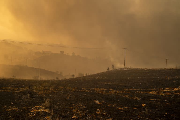 El humo se eleva desde el suelo quemado en una zona boscosa al norte de Atenas. Photo: Angelos Tzortzinis/dpa