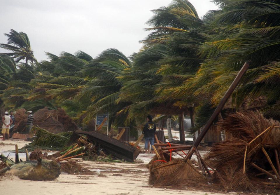 People survey the damage caused by Hurricane Ernesto after it made landfall overnight in Mahahual, near Chetumal, Mexico, Wednesday, Aug. 8, 2012. (AP Photo/Israel Leal)