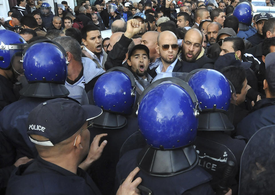Protestors face police officers in Algiers