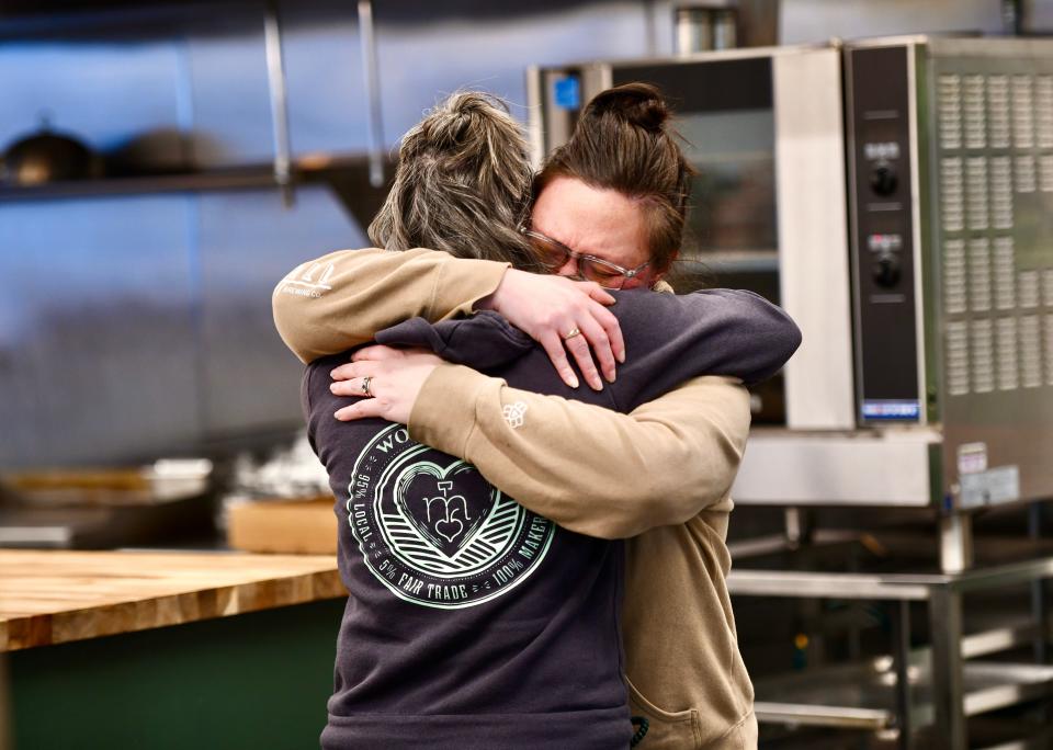 Store manager Jessica Gavin, right, hugs owner Lynn Cheney inside Maker to Main on Friday morning.