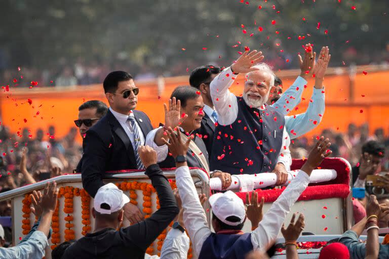 Arrojan pétalos para dar la bienvenida al primer ministro indio Narendra Modi, de chaleco, al arribar junto con el primer ministro de Assam, Himanta Bishwa Sarma, a un acto en Guwahati, India, 4 de febrero de 2024. 