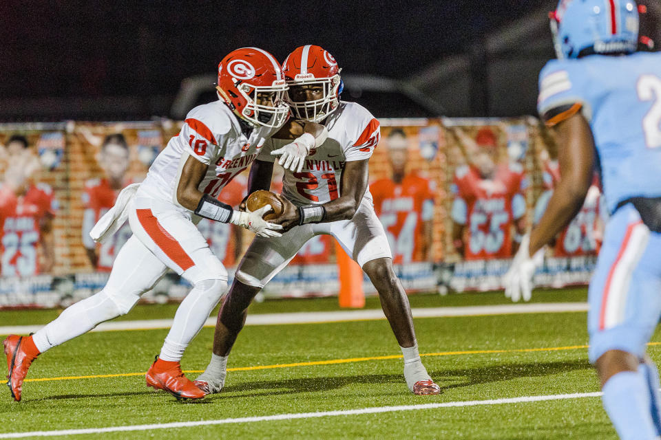 Greenville's quarterback Prometheus Franklin (21) hands-off to Jayden Pepper (10) in this file photo taken from last week's second round of the playoffs. Greenville hosts Irmo in the third round Friday.