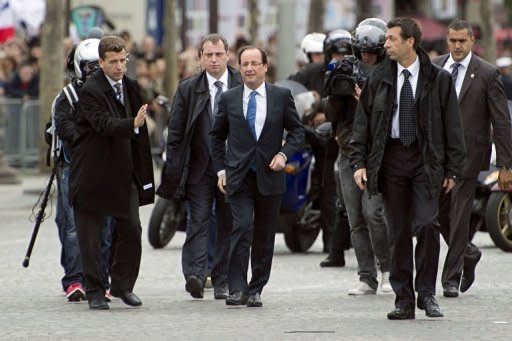 France's president-elect Francois Hollande (C) arrives to take part in a ceremony marking the 67th anniversary of the Allied victory over Nazi Germany in World War II, in Paris. Hollande formally takes office on May 15 and shortly thereafter travels to Germany for his meeting with Merkel