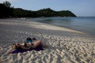 A woman sunbathes along the beach at the Anantara Rasananda resort on the island of Koh Phangan off the coast of Koh Samui, Thailand.