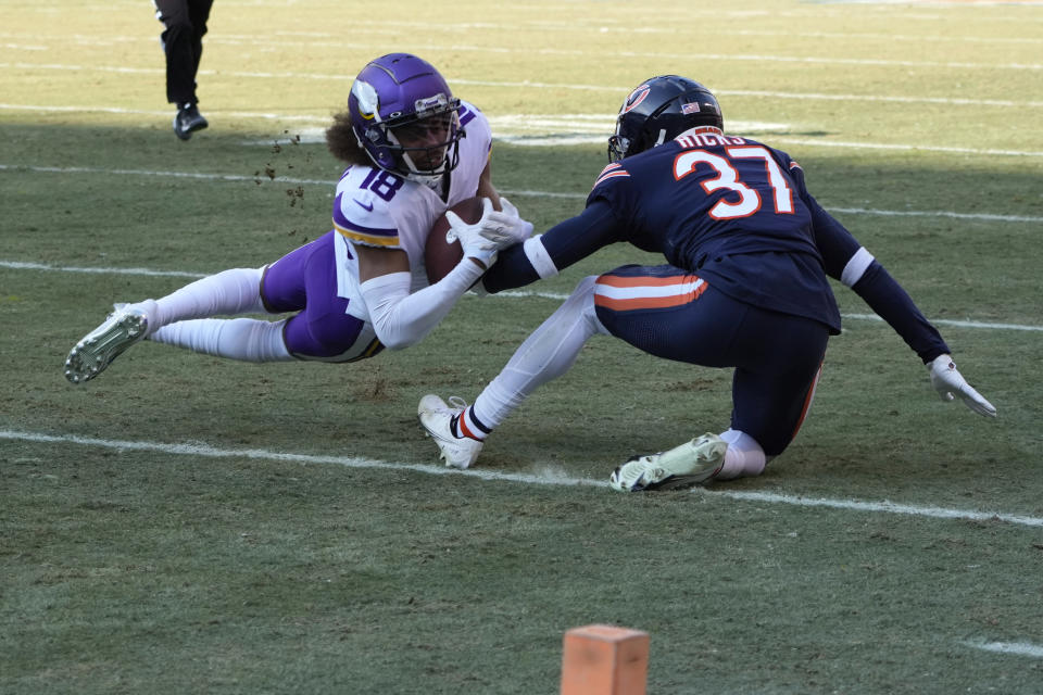 Minnesota Vikings wide receiver Justin Jefferson (18) catches a pass in front of Chicago Bears safety Elijah Hicks (37) during the first half of an NFL football game, Sunday, Jan. 8, 2023, in Chicago. (AP Photo/Charles Rex Arbogast)