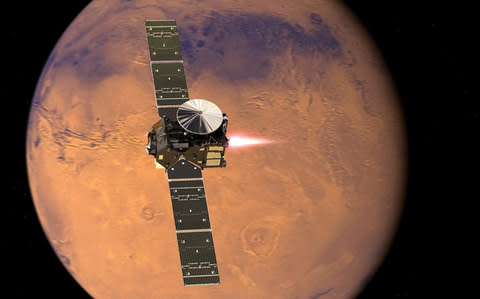 Undated handout photo issued by the European Space Agency of an artist's impression of the ExoMars 2016 Trace Gas Orbiter entering orbit as the European spacecraft nearing the end of its journey to Mars. - Credit: PA