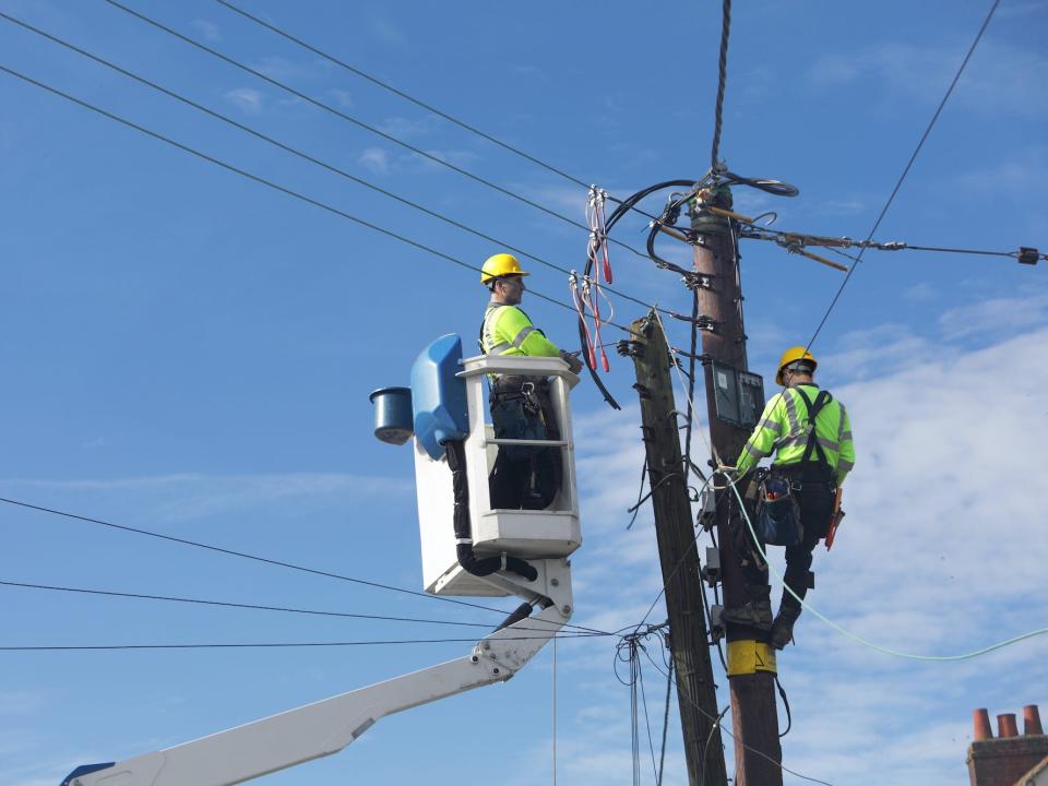 Two people working on power lines