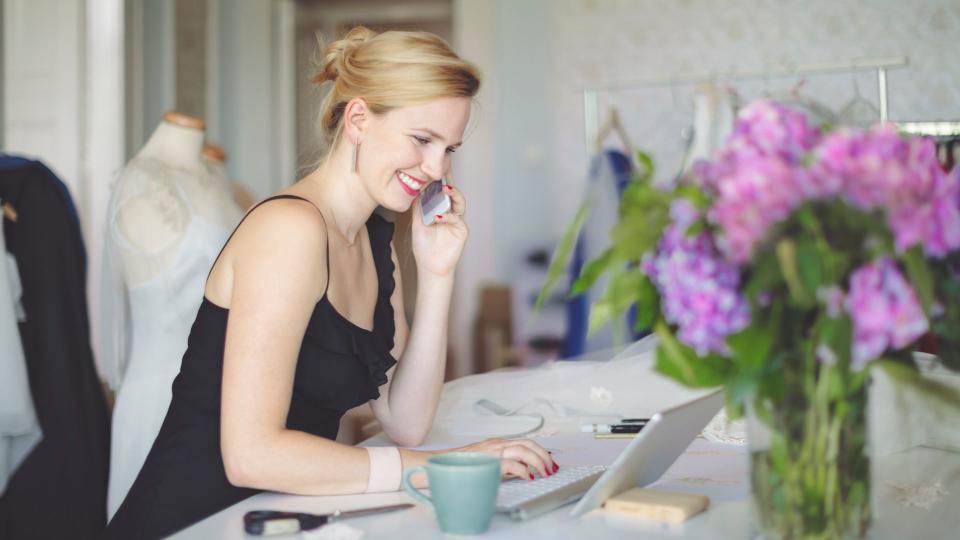 women on laptop talking on phone