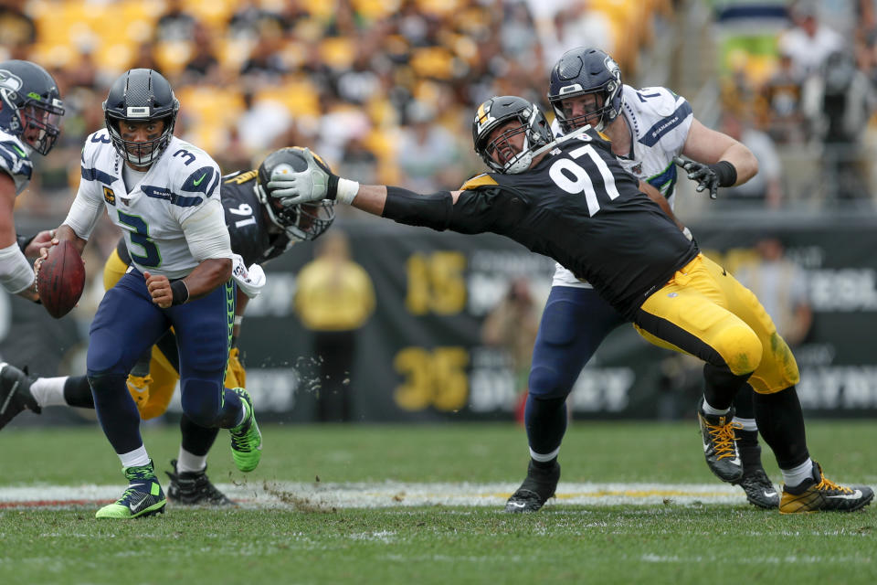 Seattle Seahawks quarterback Russell Wilson (3) scrambles away from Pittsburgh Steelers defensive end Cameron Heyward (97) on his way to a first down in the second half of an NFL football game, Sunday, Sept. 15, 2019, in Pittsburgh. (AP Photo/Don Wright)