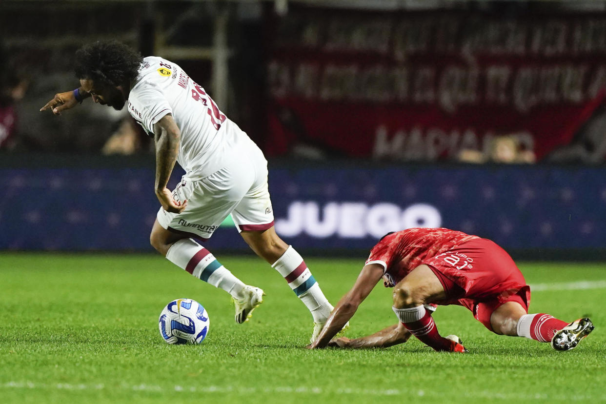 Luciano Sánchez of Argentina's Argentinos Juniors, right, falls injured during a play against Marcelo of Brazil's Fluminense, left, during a Copa Libertadores round of 16 first leg soccer match at Diego Armando Maradona stadium in Buenos Aires, Argentina, Tuesday, Aug. 1, 2023. (AP Photo/Ivan Fernandez)