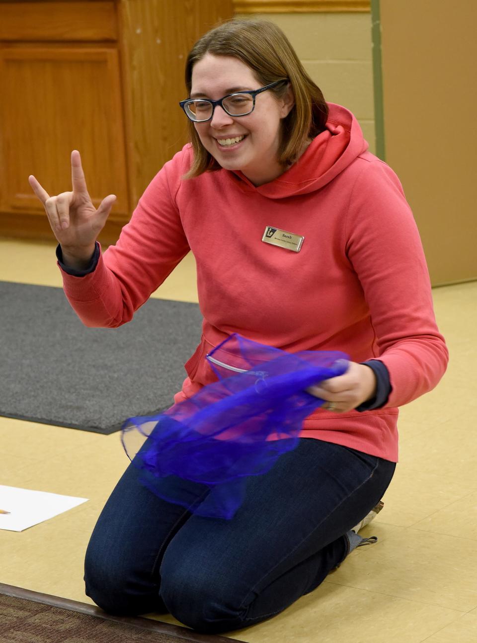 Sarah Seegert, the youth services technician at Summerfield-Petersburg Branch Library, says "I love you" in sign language during a song at the baby sign language program.